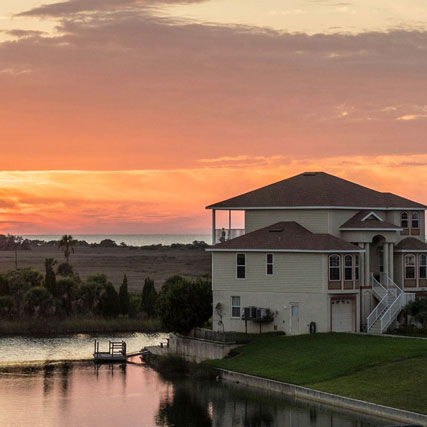 A house against the water and sunset.